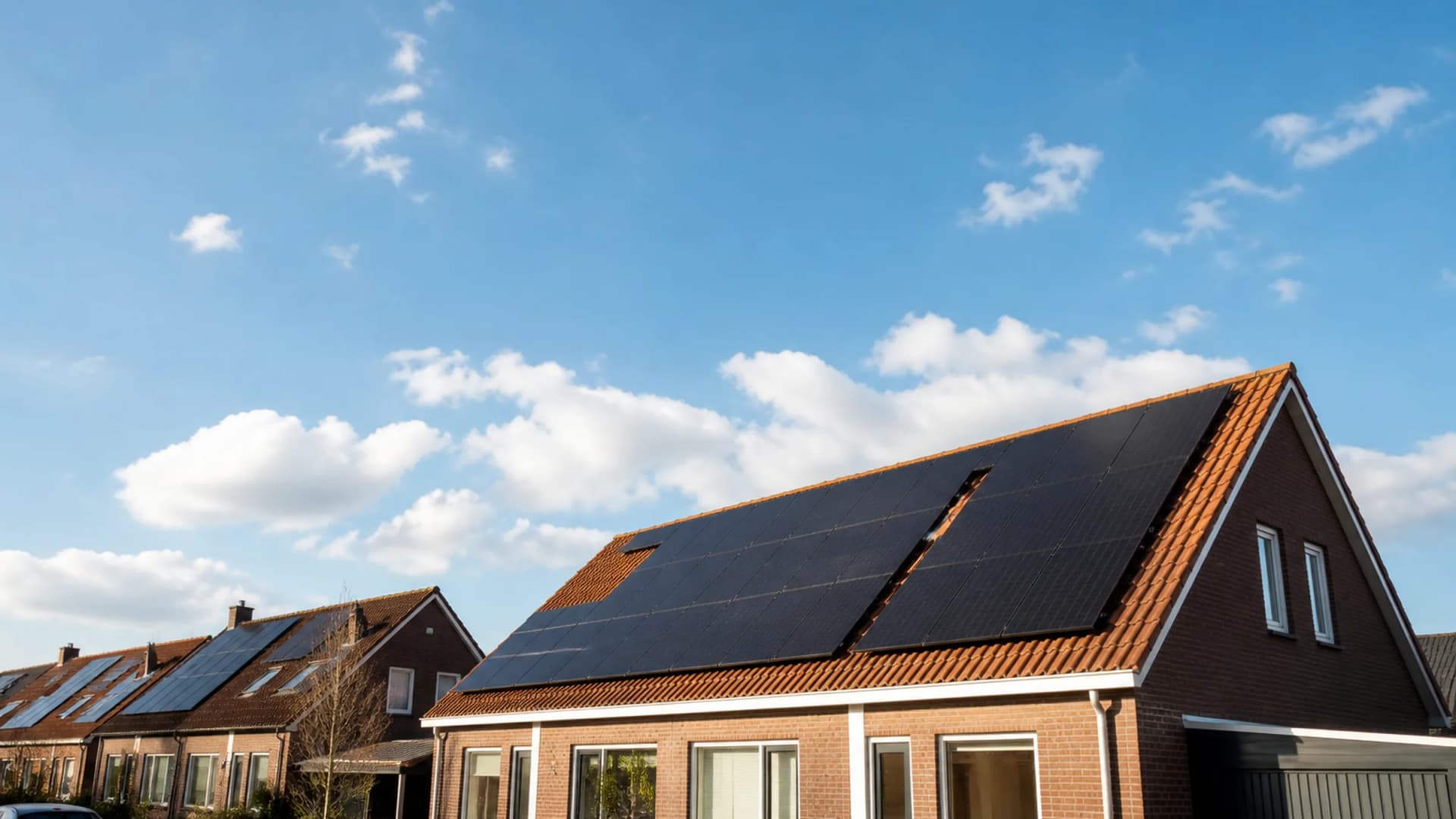 Sunny Dutch home with solar panels on the roof under a clear blue sky