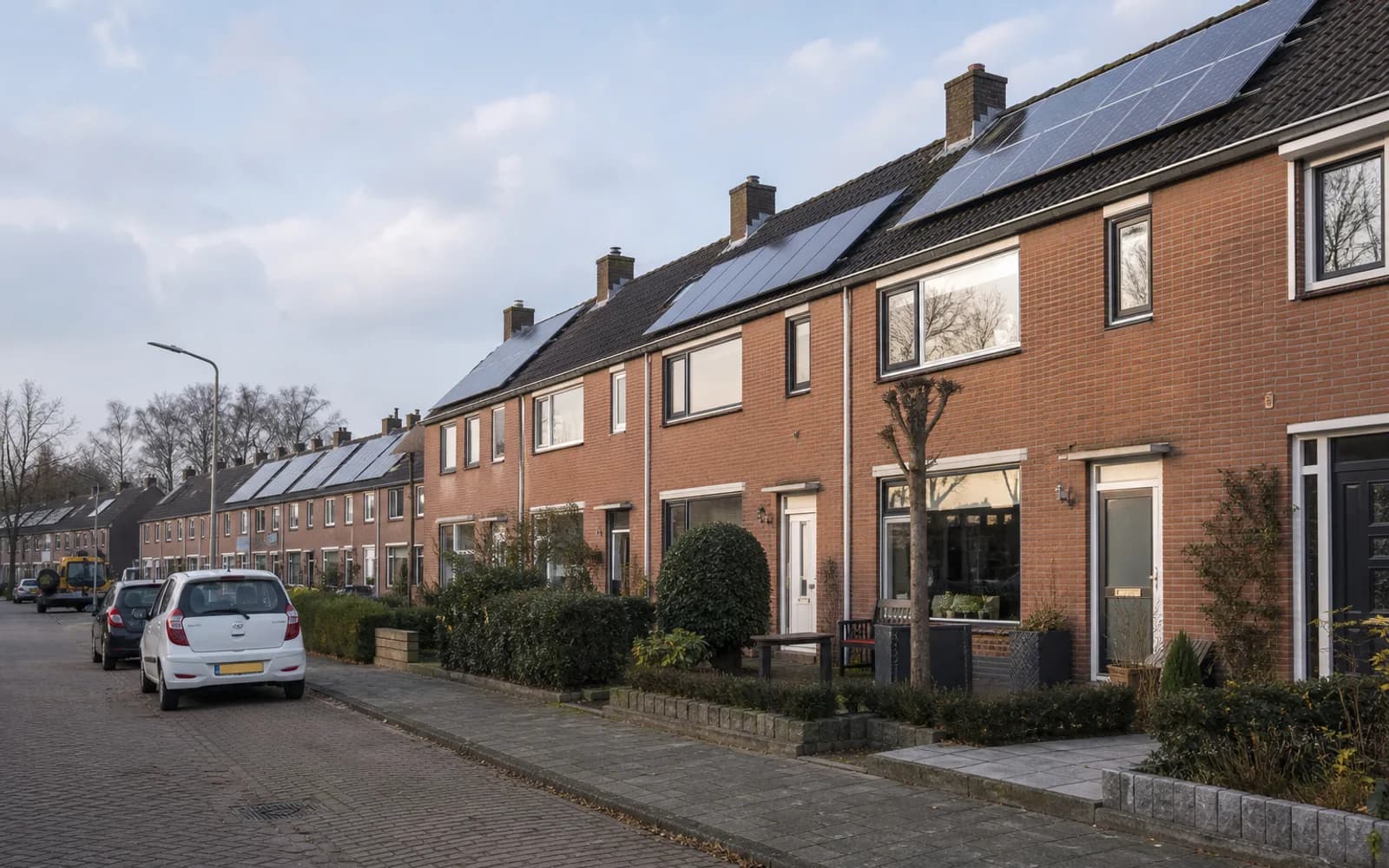 Rij woningen met zonnepanelen in een Nederlandse wijk