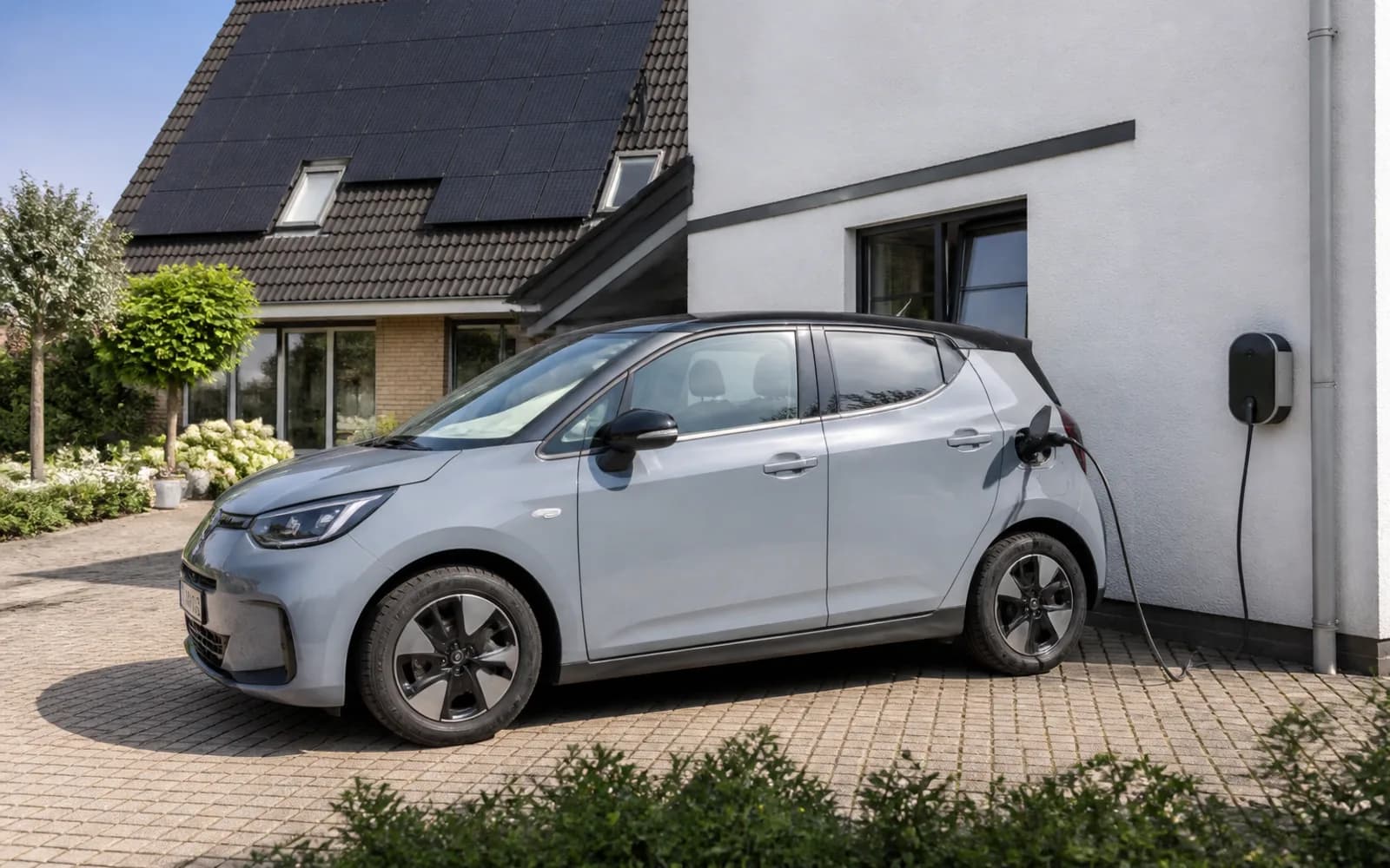 Electric car charging at a house with rooftop solar panels