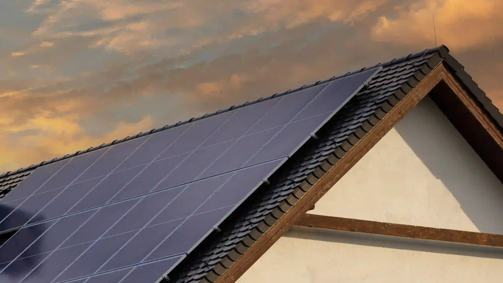 Woning met zonnepanelen op het dak bij zonsondergang