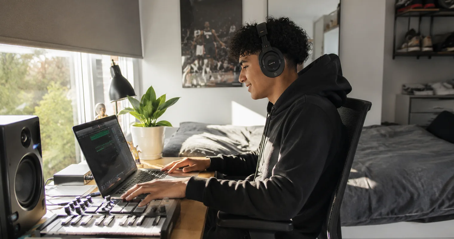 Young man working with a laptop and music gear on power from the home battery